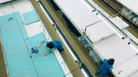 Fast motion of factory staff working with textile in a top view