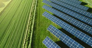 Top view of a new solar farm. Rows of modern photovoltaic solar panels next to the green field. Renewable ecological source of energy from the sun. Aerial view. - Powered by Shutterstock - Get 15% off with code: PIKWIZARD15