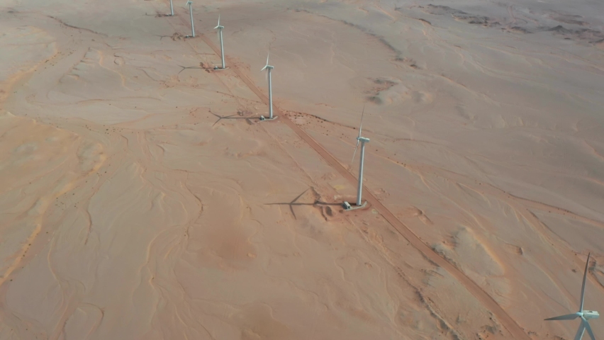 Aerial zoom in shot of a row of windmills in Red Sea desert, Egypt Royalty-Free Stock Footage #1081561763
