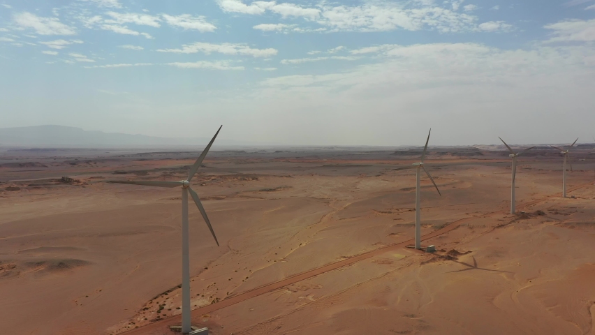 Panning Aerial drone shot of row of windmills in the desert with beautiful clouds Royalty-Free Stock Footage #1081562330