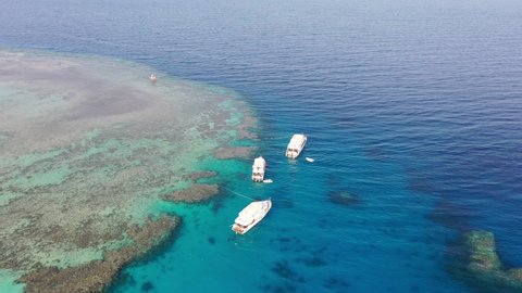 Zoom out aerial drone shot of Three Yachts in the Red Sea, Egypt