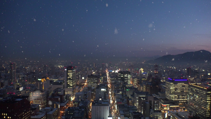 SAPPORO, HOKKAIDO, JAPAN : Aerial view of cityscape of Sapporo and snow. View of buildings and streets around Susukino downtown. Japanese winter and romantic Christmas concept. Night time shot.