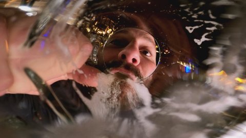 4k Beard man drinking beer or water . Beer pouring into mouth . Camera inside of beer glass or cup . Very funny angle view of camera .
