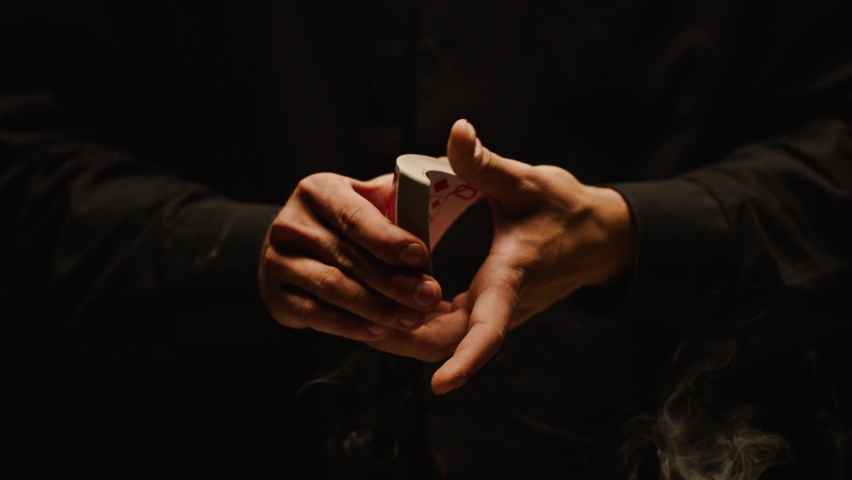 Close-up of a Magician's Hands Performing Card Trick . Throwing and Catching Cards in the Air on black Background with smoke . Card Mechanic .  Shot on ARRI Alexa cinema camera in Slow Motion  Royalty-Free Stock Footage #1081569677