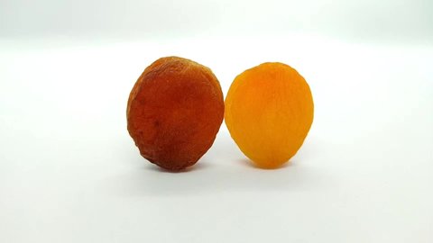 Yellow dried apricots and brown dried apricots on white background, 2 dried apricots elongated vertically