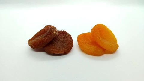 2 yellow dried apricots and 2 brown dried apricots on a white background