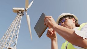 Portrait of engineer woman in safety helmet checking wind turbine system using tablet. - Powered by Shutterstock - Get 15% off with code: PIKWIZARD15