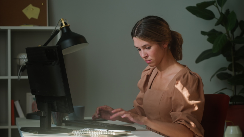 Young woman working from home office remotely, irritated businesswoman typing on keyboard, employee knocking at monitor screen and throwing. Angry worker breaking computer. Royalty-Free Stock Footage #1081575863