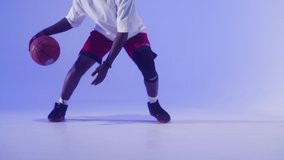 Professional basketball player on blue background. African american man playing basketball, holding orange ball. Sportsman training in studio, practicing game skills. - Powered by Shutterstock - Get 15% off with code: PIKWIZARD15