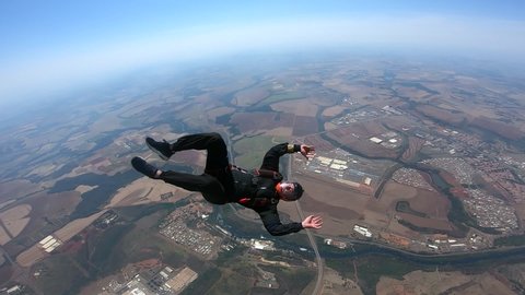 Skydiver learning back fly. Point of view of instructor. He signals to correct his position