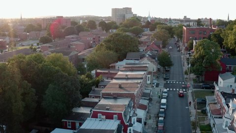 Reveal of urban city in USA at summer sunset. Establishing aerial shot.