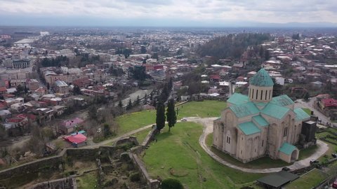 Aerial view of reconstructed building of Bagrati Cathedral in Kutaisi on background with spring cityscape. Masterpiece of medieval Georgian architecture