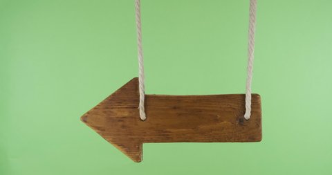 Empty swinging wooden sign hung from ropes. With space for design, text place. Isolated on green screen