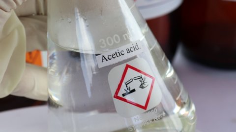 Acetic acid in glass, chemical in the laboratory and industry