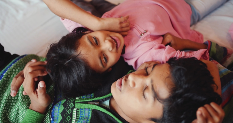 A group of Indian children happily lying on a bed
