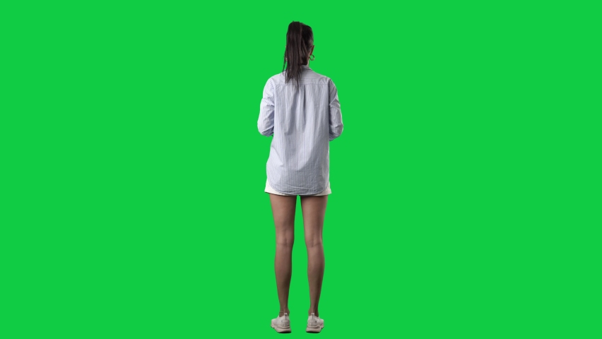 Back view of stylish young business casual woman using touch screen interactive gestures. Full body isolated on green screen background Royalty-Free Stock Footage #1081596689