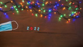 sop motion, time lapse, transition to the new year 2021 2022, with colorful numbers and colorful festive christmas lights on intermittently, the surgical health mask being pushed by the new year - Powered by Shutterstock - Get 15% off with code: PIKWIZARD15