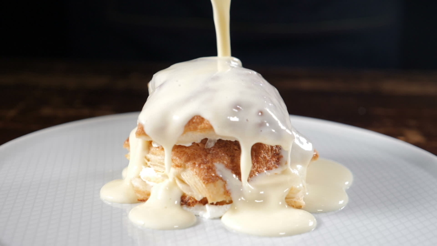 Chef cooking and serving dessert. Pouring whipped cream on cake. Sweet cream cheese pouring. Confectionary routine. preparing baking sweet bakery cake. whipped sour cream. Slow motion. Full hd