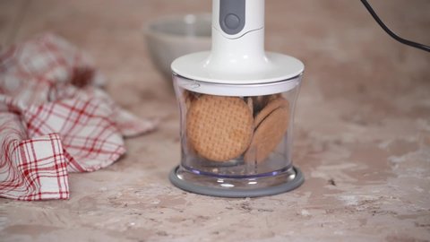 Grinding cookies in a blender. Making a dessert from shortbread cookies.