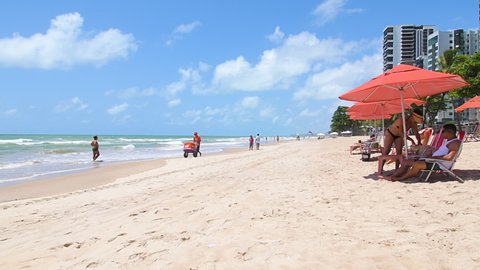 Recife, PE, Brazil - October 14, 2021: bathers and vendors at the beach of Boa viagem. People enjoying the day at the beach on a beautiful sunny day.