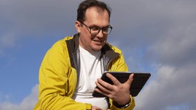 Man answers a video call using a tablet outdoors