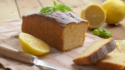 Lemon pound cake on rustic wooden background with lemon and mint.