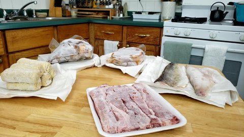 Home cooking - Checking or showing lot of air sealed and or frozen food like fish, pork, beef and some croquettes battered in breadcrumbs thawing before cooking.