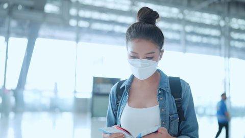 young asian female woman casual cloth hand show passport and ticket to check in  travel vacation at staff airline kiosk,safety travel asian female with mask at airport terminal checking in for flight 