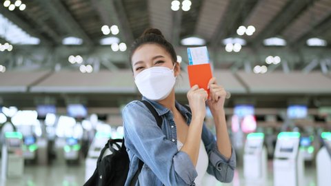 happiness smiling asian adult female wear face mask hand gesture showing passport and blank screen smartphone at aitport terminal,asian female ready to travel after lockdown ia over at airport