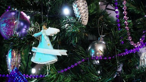 2021 Christmas concept: Blue angel  ornament. Lights of a festive decorated tree glittering at night. Decoration for New Year celebration in 4k resolution. Illuminated Xmas decor background. 