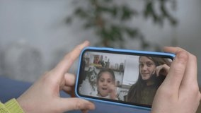 teenager girl greet friends on smartphone screen. Children use gadget while chatting with friends. Video on smartphone screen with cheerful children. Modern technologies of teenager communications.