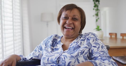 Portrait of happy african american senior woman smiling to camera. retirement lifestyle, leisure time alone at home.