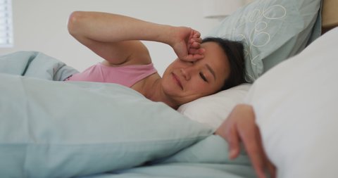 Asian woman lying in bed, waking up in the morning. lifestyle, spending time and relaxing at home.