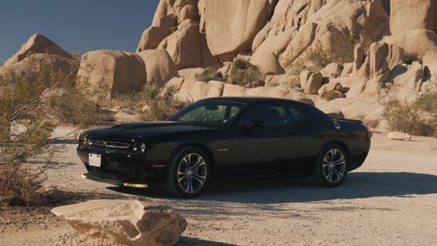 Mojave Desert, USA - September 2,2021:American muscle car Dodge Challenger in the sand desert. It is the name of three different generations of automobiles produced by automobile manufacturer Dodge