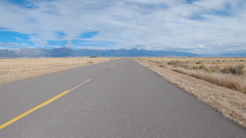 Driving down deserted Colorado highway towards the Rocky Mountains during fall