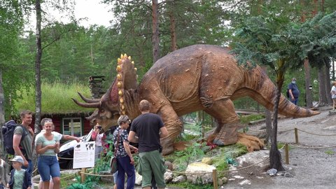 Flaa , Viken , Norway - 07 10 2021: Triceratops Horridus recreation in Dinosauria theme park Norway - Families walking around real size dinosaur model with moving head - Static clip