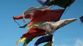 Video of Religious tibetan buddhist prayer flags. Flags are flutter in the wind on blue sky background.  Altai, Siberia, Russia