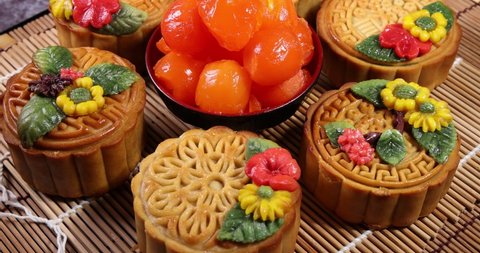 Mid autumn festive colorful flower decorated moon cake making ingredients salted egg yolk background on bamboo food mat move rotate