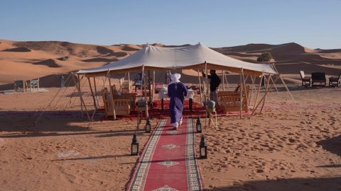 Merzouga , Morocco - 08 02 2021: Man serving food on the table at a luxury camp in Sahara Desert, pov tourist shot