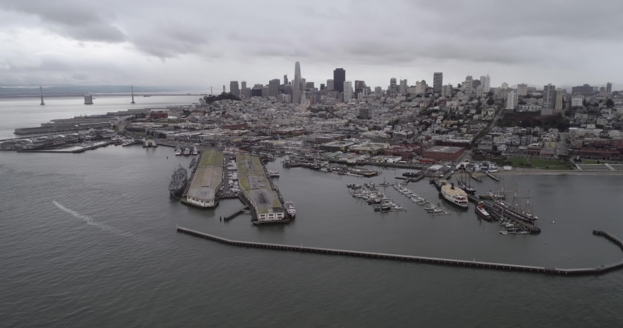 San Francisco Cityscape and Fisherman Wharf in Background. Cloudy Day. Aquatic Park Pier, Cove and Municipal Pier in San Francisco. Maritime National Historic Park in Background. California