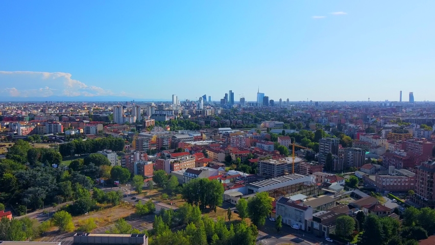 Black smoke from a fire of a residential skyscraper in the city. Aerial view of the city skyline with new high-rise buildings. Emissions of carbon dioxide into the atmosphere. Italy, Milan 08.30.2021 