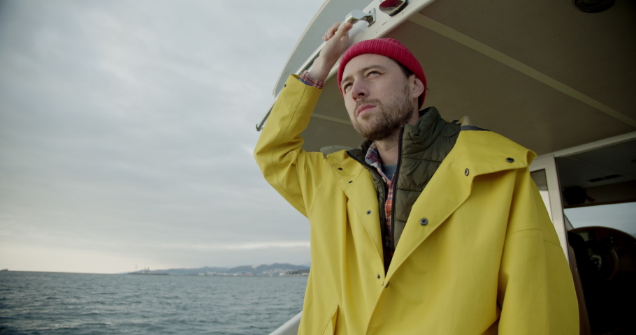 sailor on a boat in the open ocean looks at the horizon and smiles. Portrait of a fisherman on a ship. Fishing in Norway. Royalty-Free Stock Footage #1081680158