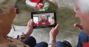 Senior caucasian couple using tablet for christmas video call with smiling woman on screen. christmas, festivity and communication technology.