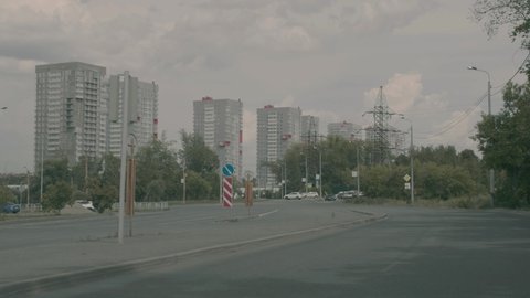 Moving footage of a car driving on the road in the Russian city of Chelyabinsk. The movement of a car on an empty road against the backdrop of tall houses in summer.
