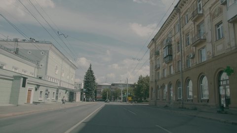 Car driving on the road of the streets of Chelyabinsk, Russia. The movement of the car against the background of tall houses. The driver turns at a traffic lightwhile passing a pedestrian crossing.
