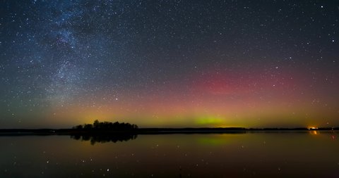 Timelapse with Milky way and Northern lights - Aurora borealis over the lake in Lithuania