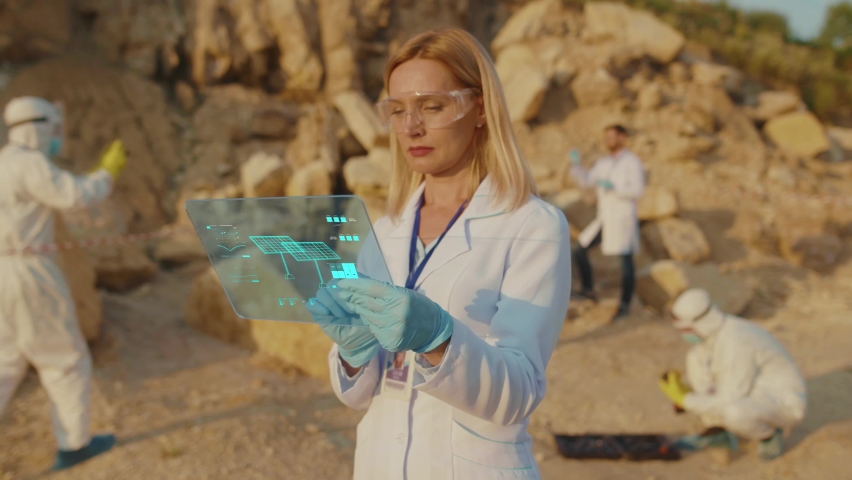 Beautiful Smart Expert Explores Digital Data about Solar Panel System on Holographic Tablet Computer. Team of Professional Ecology Workers Planning New Plant Construction. Alternative Energy