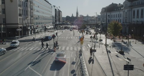Stockholm, Sweden - 10 22 2021: A view on a sunny day of Vasagatan road with people crossing the street, from a bridge on Klarabergsgatan road in Stockholm city centre, during pandemic.