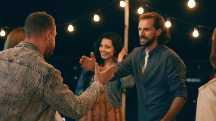Good looking guy came to the party he say he to everyone and hugging his friends on the rooftop of terrace Royalty-Free Stock Footage #1081698959