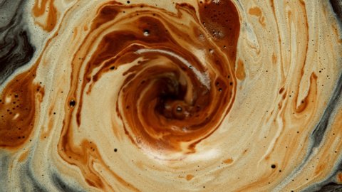 Super slow motion Shot of Swirling Coffee and Cream 